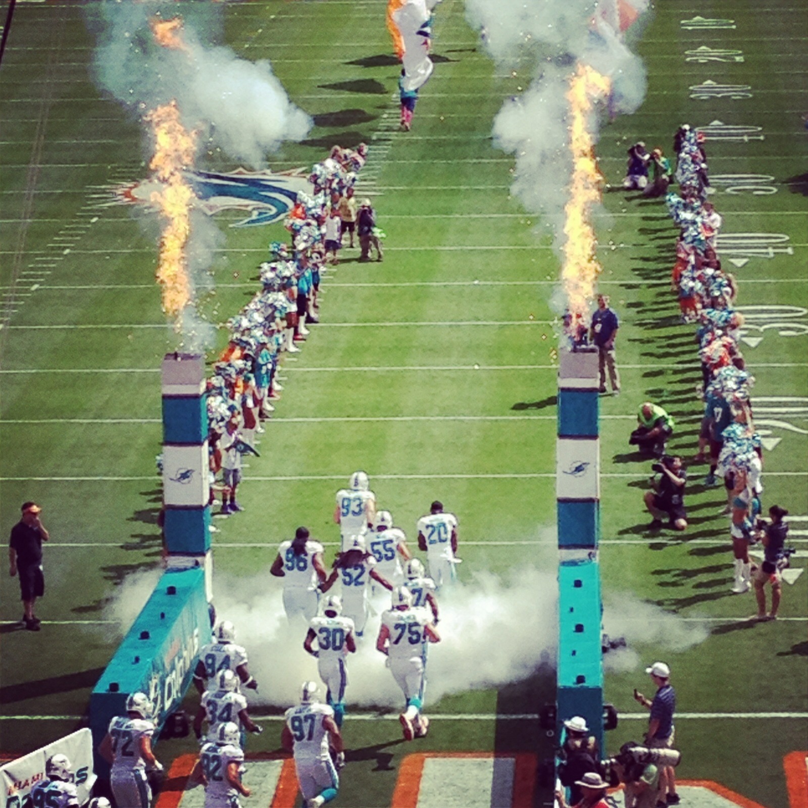 Miami Dolphins players running out of the tunnel with pyrotechnics